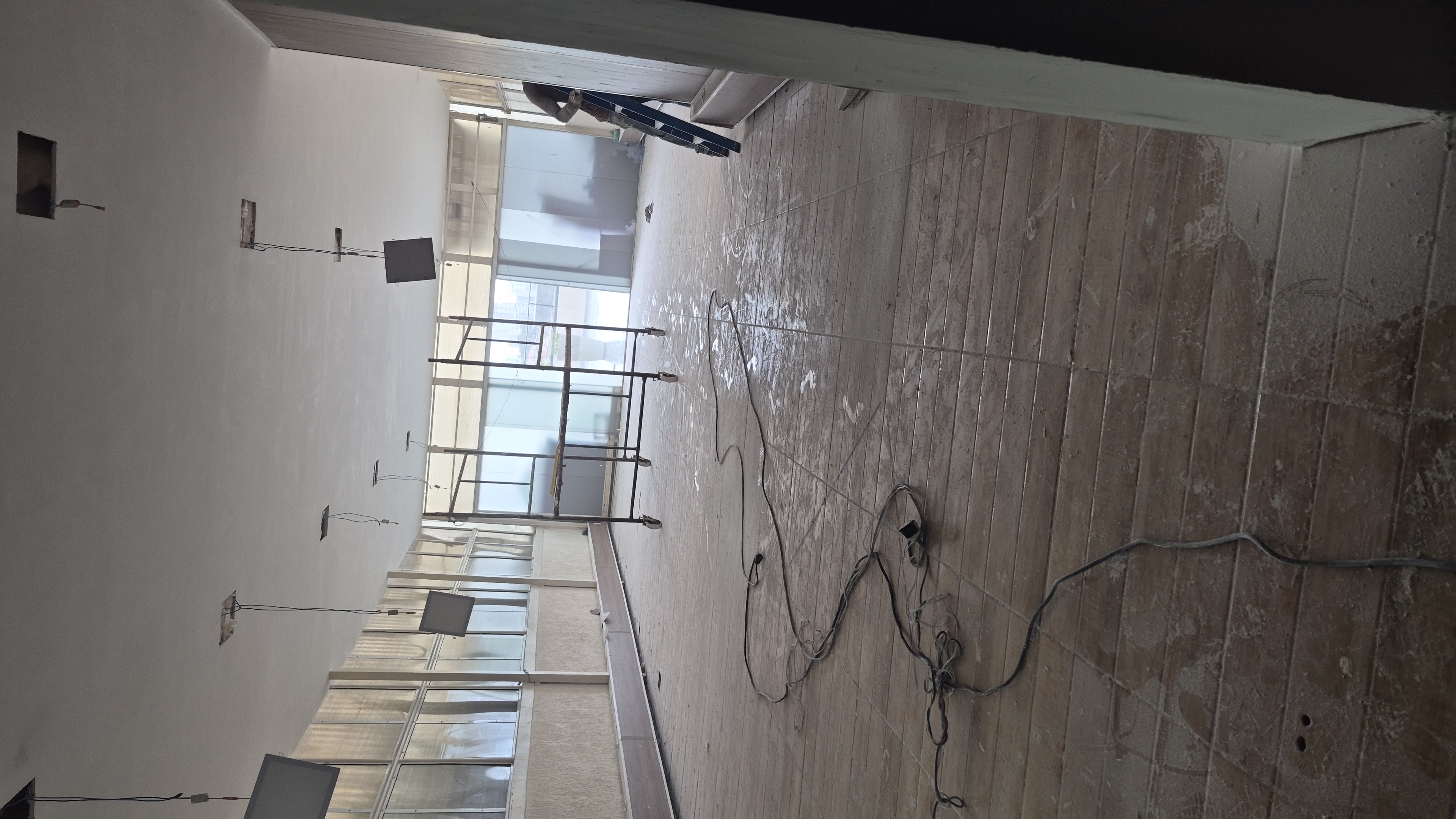 Ambiente residencial amplo com piso protegido e pintura em andamento