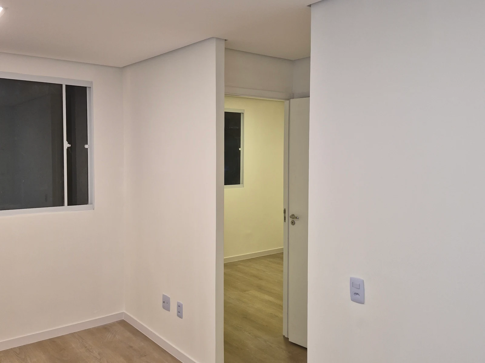 Quarto residencial finalizado em Osasco com paredes claras e piso amadeirado